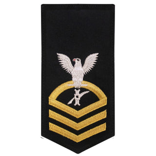 USN Female Rating Badge: E-7 Legalman (LN) - Standard Seaworthy Gold on Blue for Service Dress & Dinner Dress Blue uniform. Gold chevrons indicate 12 years of consecutive good conduct.  - CPO embroidered Regulation Gold Chevron on Blue with White Eagle and Designator.  - Gold & White Embroidery on Dark Blue Polyester Wool. - US Navy Certified - Made in the USA