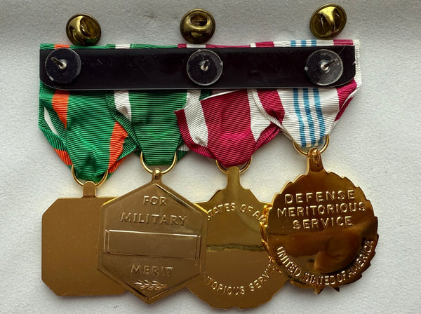 Genuine official used/pre-owned U.S. Military Armed Forces Medal Rack Set includes Regulation Full Size Medals (l-r): Defense Meritorious Service Anodized Medal, Meritorious Service Anodized Medal, Navy & Marine Corps Commendation Anodized Medal with 3 bronze stars, Navy & Marine Corps Achievement Anodized Medal. Mounted on bar, Made in the USA.