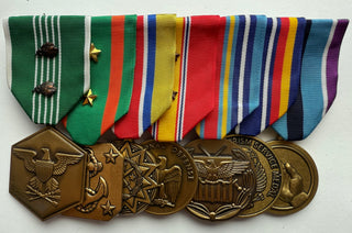 Genuine U.S. Military Armed Forces Medal Rack Set. Set includes Standard Regulation Full Size Medals (l-r): Army Commendation Medal with 2 bronze oak leaf cluster, Navy & Marine Corps Achievement Medal with 2 gold stars, Army Reserve Components Achievement Medal, National Defense Service Medal with 2 bronze stars, Global War on Terrorism Expeditionary Medal, Global War on Terrorism Service Medal, Humanitarian Service Medal. Mounted on a bar, Official U.S. Military Grade Medals, Made in the USA.