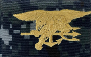 US NAVY Working Uniform Type 1 Embroidered Badge - Special Warfare. Gold embroidery on Blueberry Camo.  Official U.S. Navy patch to display on your "love me" wall. Digital Blue Camouflage (retired in October 2019).  - USN Certified - NWU Type 1 Blue Digital Camouflage (Blueberries) - Individually sold - Fabric: 50% Nylon / 50% Cotton Twill - Made in the USA
