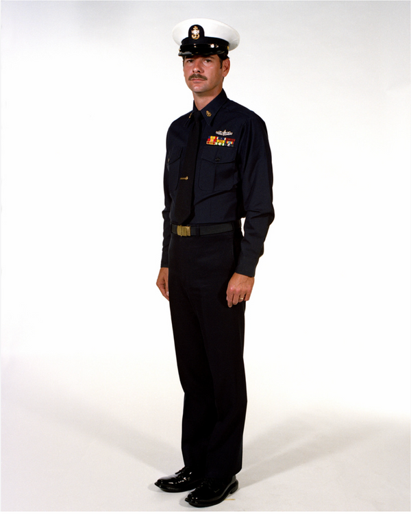 Navy CPO Winter Service Blue Uniform worn with white combination dress cap cover, black neck tie, ribbons & badges.