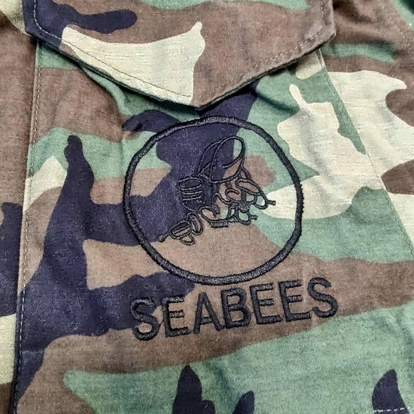 SEABEES logo insignia embroidered on M-65 Woodland Camo Field Coat Jacket Pocket.
