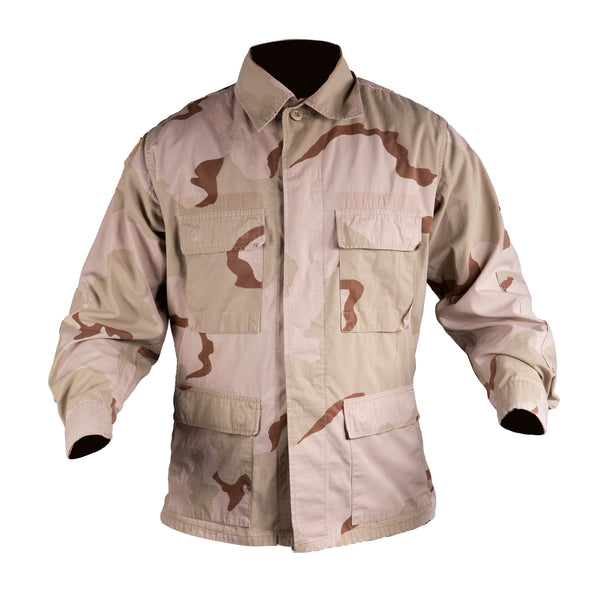 DCU Tri-Color Desert Camo Blouse. U.S Military Desert Combat Uniform Shirt Jacket in Tri-Color Desert Camo. Official, Military issue DCU Tri-Color Desert tan camouflage pattern. This camo is also known as the Desert Combat Uniform (DCU) worn by all Armed Forces. This coat features a full button front, 4 front button-flap pockets, and button tab cinch cuffs. Nylon/Cotton Ripstop. Genuine Military-issue uniform. Made in the U.S.A.