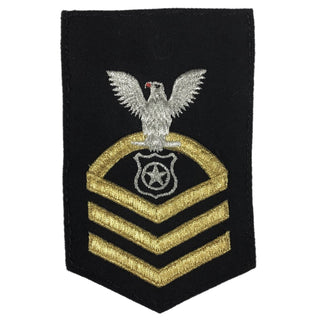 USN Female Rating Badge: E-7 Master At Arms (MA) - Seaworthy Gold on Blue for Dress Blue & Dinner Dress Blue uniform. CPO embroidered Regulation Gold Chevron on Blue with White Eagle and Designator. Gold Chevrons Indicating Good Conduct Service.  - Fabric: Silver White & Gold Embroidery on Dark Blue Wool - Quality = Seaworthy/ Standard - US Navy Certified - Made in the USA - Condition: Good, pre-owned/gently used unless marked as NEW.